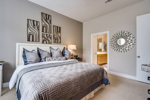 A bedroom with a large bed and a mirror on the wall.