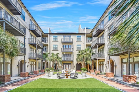 A sunny day at a courtyard surrounded by apartment buildings.