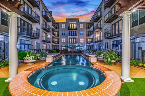 A swimming pool in the middle of a courtyard surrounded by buildings.