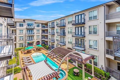 A large apartment complex with a pool and a hot tub.