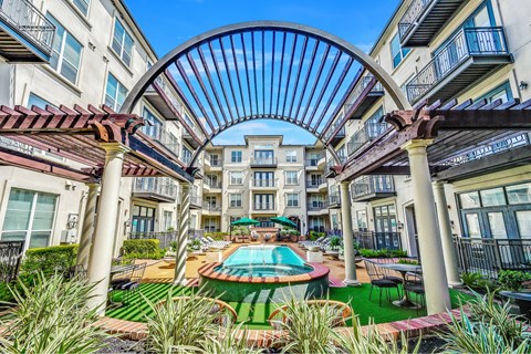 A pool surrounded by a metal archway in a residential area.