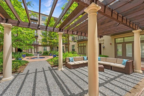 A patio with a bench and pillars.