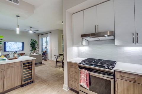 A modern kitchen with wooden cabinets and a stove top oven.