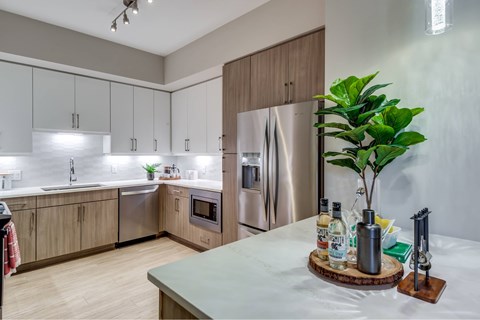 A kitchen with a marble table and stainless steel appliances.