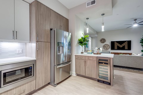 A modern kitchen with stainless steel appliances and wooden cabinets.