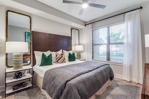 A bedroom with a large bed and a mirror on the wall.