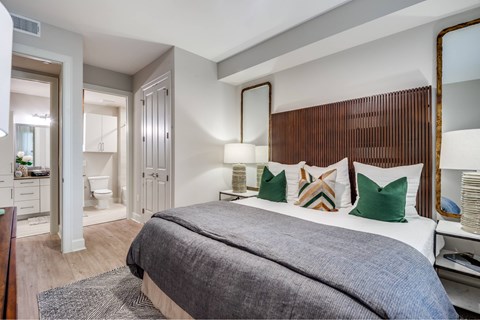 A bedroom with a large bed and a mirror on the wall.