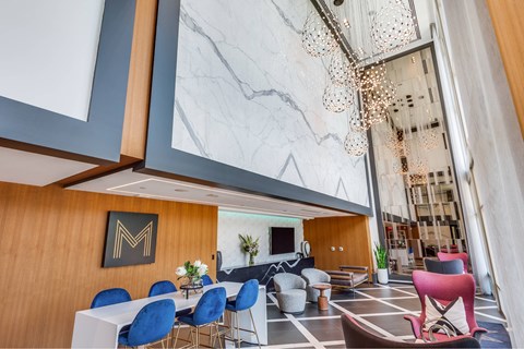 A modern dining area with a white table and blue chairs.