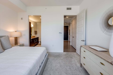 A bedroom with a large bed and a dresser.