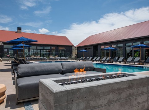 A pool area with a fire pit in the center.