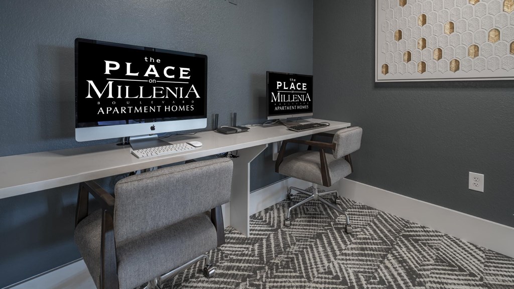 A room with a desk and chairs with a sign that says "The Place Millenia Apartment Homes".