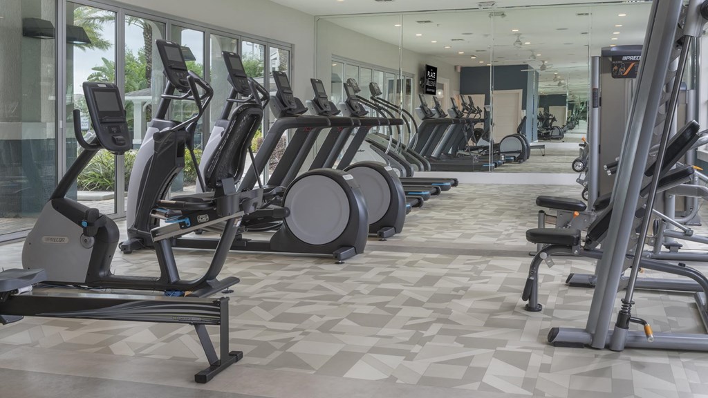 A gym with treadmills, elliptical machines, and other exercise equipment.