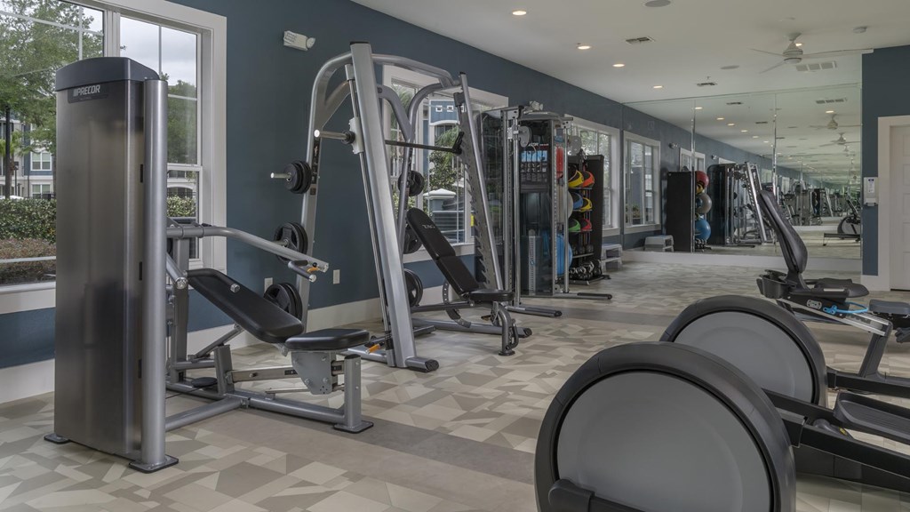 A gym with a variety of equipment including weights and machines.