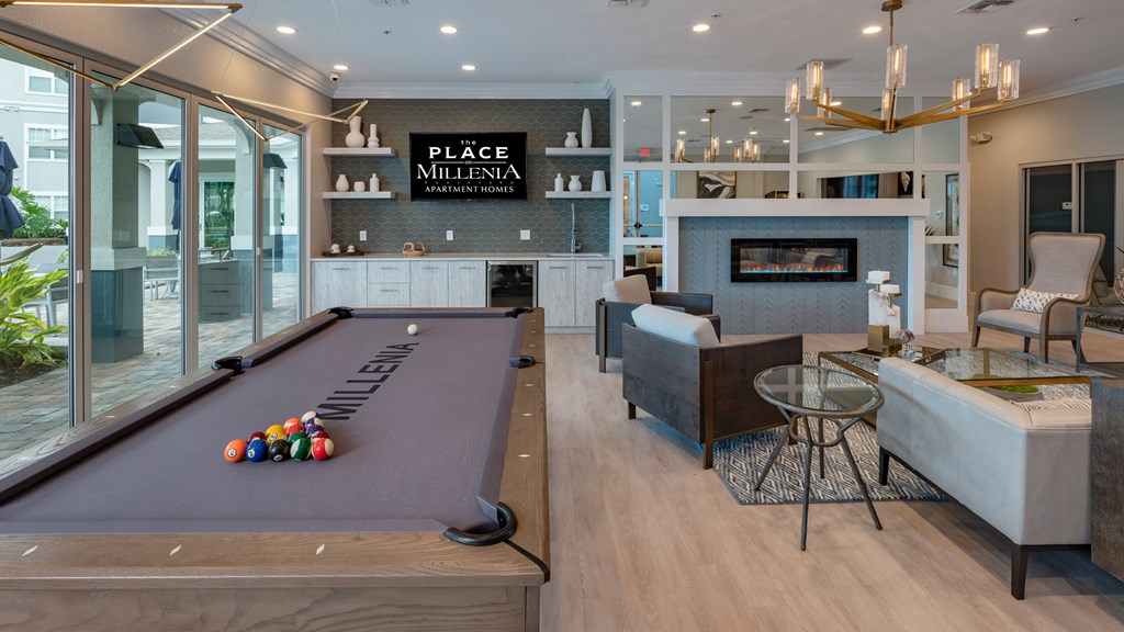 A pool table with balls on it in a room with a sign that says Place Millenia.