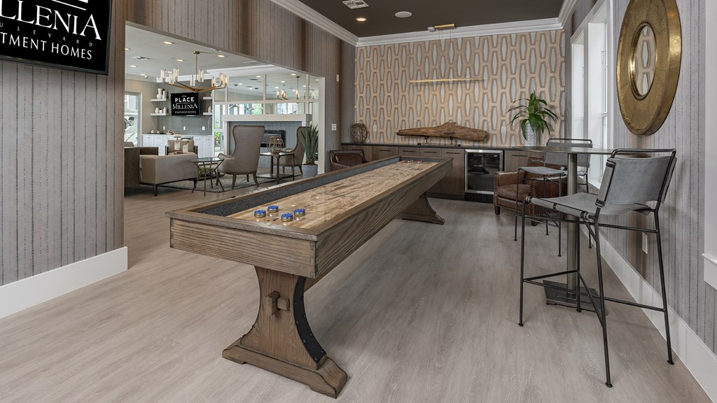 A room with a pool table and a sign that says "Ellenia Investment Homes".