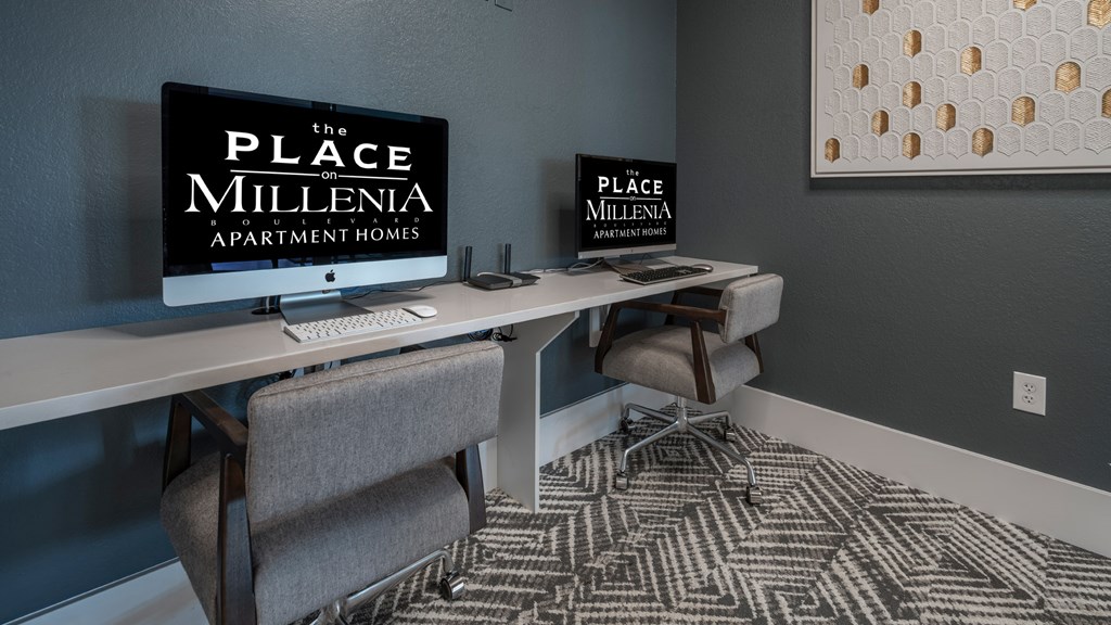 A room with a desk and chairs with a sign that says "The Place Millenia Apartment Homes".