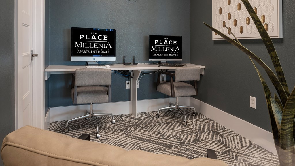 A room with a desk and a couch with a sign that says "The Place Millenia Apartment Homes".