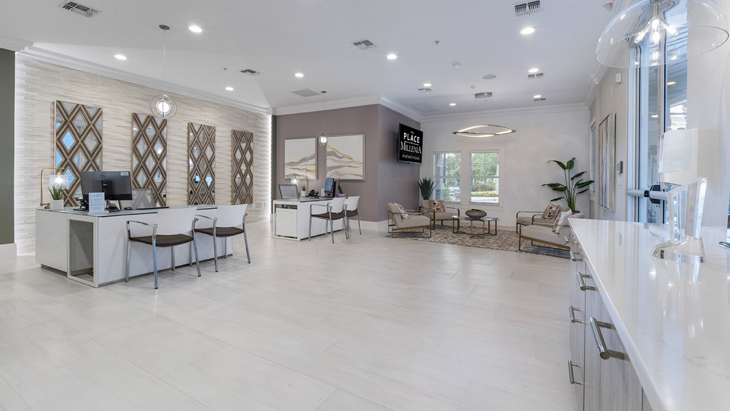 A spacious office with a reception desk and multiple seating areas.