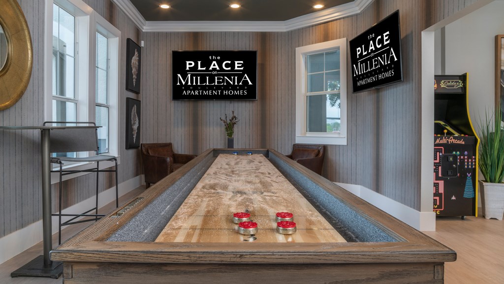 A pool table in a room with a sign that says "The Place Millenia Apartment Homes".
