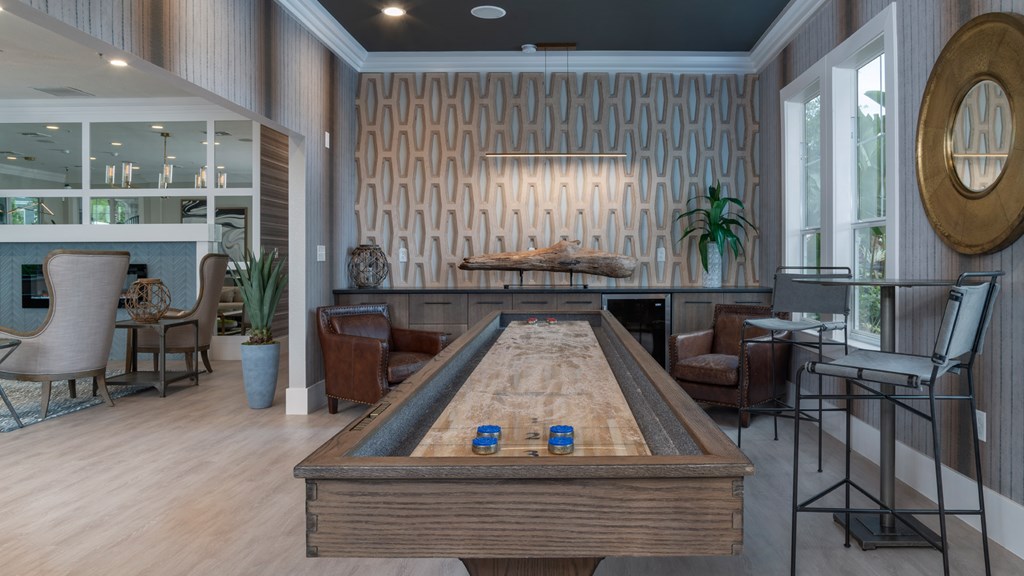 A pool table is surrounded by chairs in a room with a wood panelled wall.