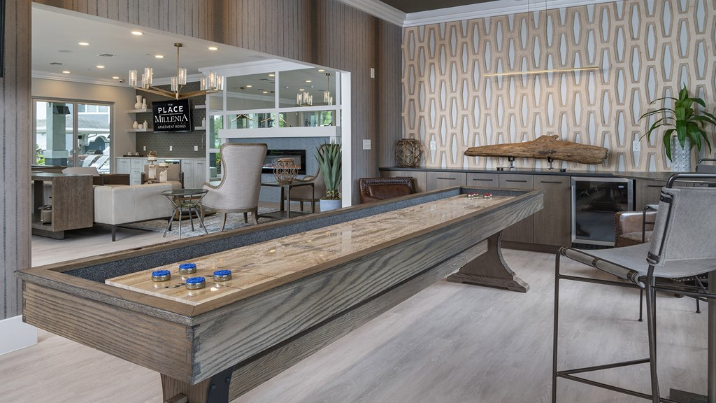 A shiny wooden table with blue bottles on it is in the middle of a room.