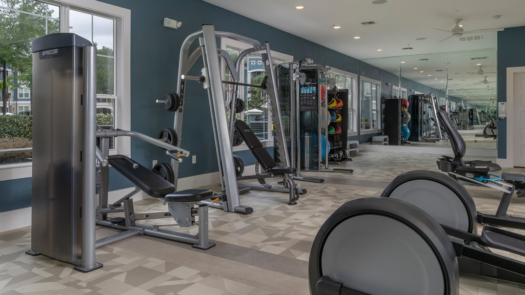 A gym with a variety of equipment including weights and machines.