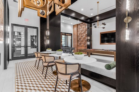 A modern dining room with a checkered floor and a wooden table.