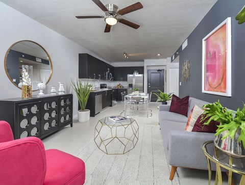 A living room with a red chair and a grey couch.
