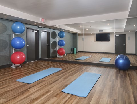A gym with exercise balls and mats.