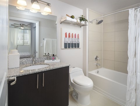 A bathroom with a white toilet, sink, and bathtub.