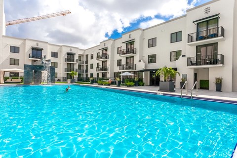 A large swimming pool in front of apartment buildings.