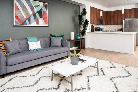 A living room with a grey couch and a white coffee table.
