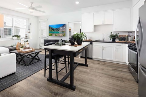 A modern kitchen with a table and chairs in the middle.