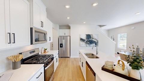 A modern kitchen with white cabinets and stainless steel appliances.