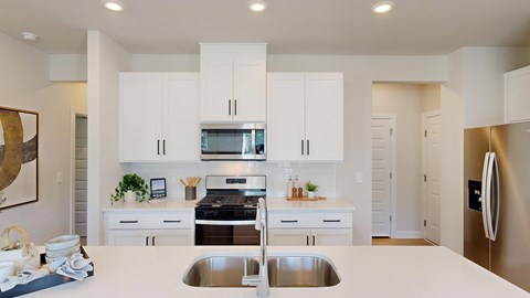 A modern kitchen with white cabinets and stainless steel appliances.