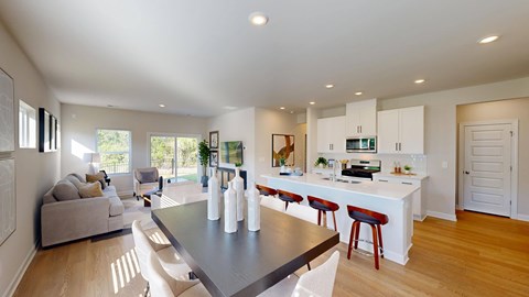 A modern kitchen with a dining table and chairs.