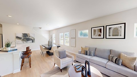 A living room with a grey couch and a wooden table.