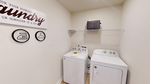 A small laundry room with a sign that says "Check your pockets or consider it a tip".