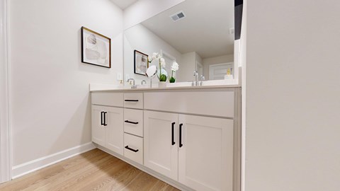 A white cabinet with drawers and doors is in a room.