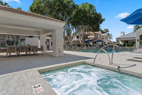 A hot tub in the middle of a pool surrounded by a building.