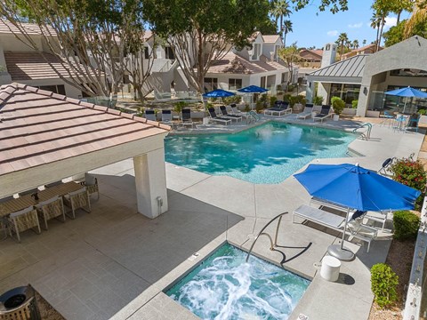 A pool with a slide and a hot tub.