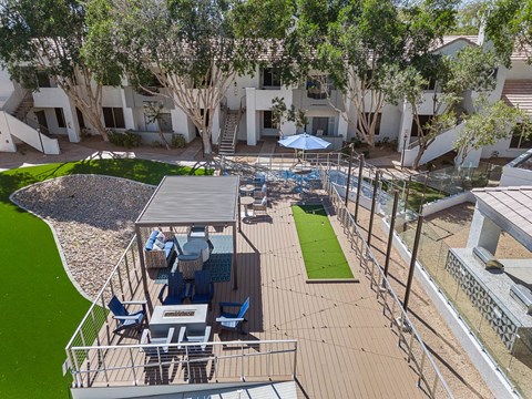 A patio with a table and chairs is surrounded by a metal fence.