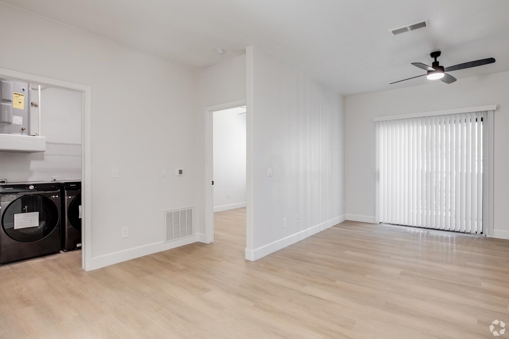 A room with a ceiling fan and a washing machine.