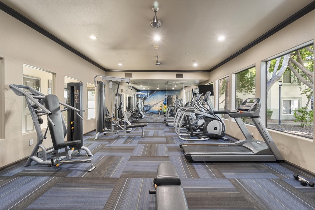 A spacious gym with treadmills, elliptical machines, and other exercise equipment.