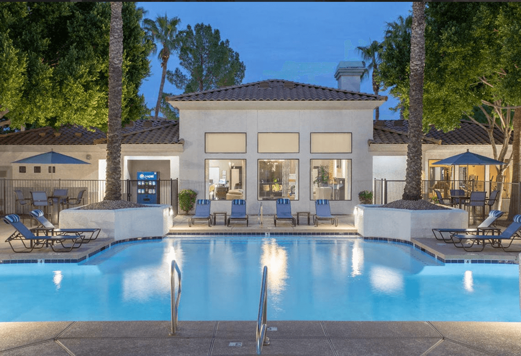 A large house with a pool in front.