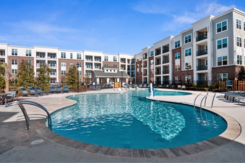 A large swimming pool in front of apartment buildings.