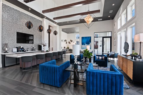 A modern living room with a blue sofa and a grey and white patterned wallpaper.