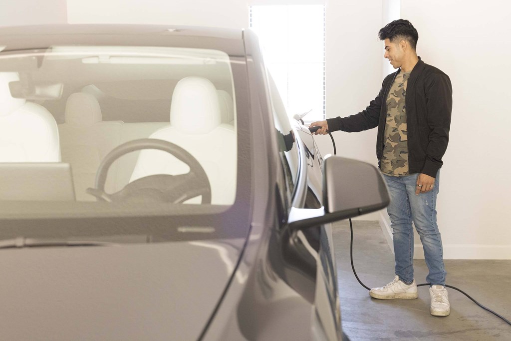 A man is charging an electric car.