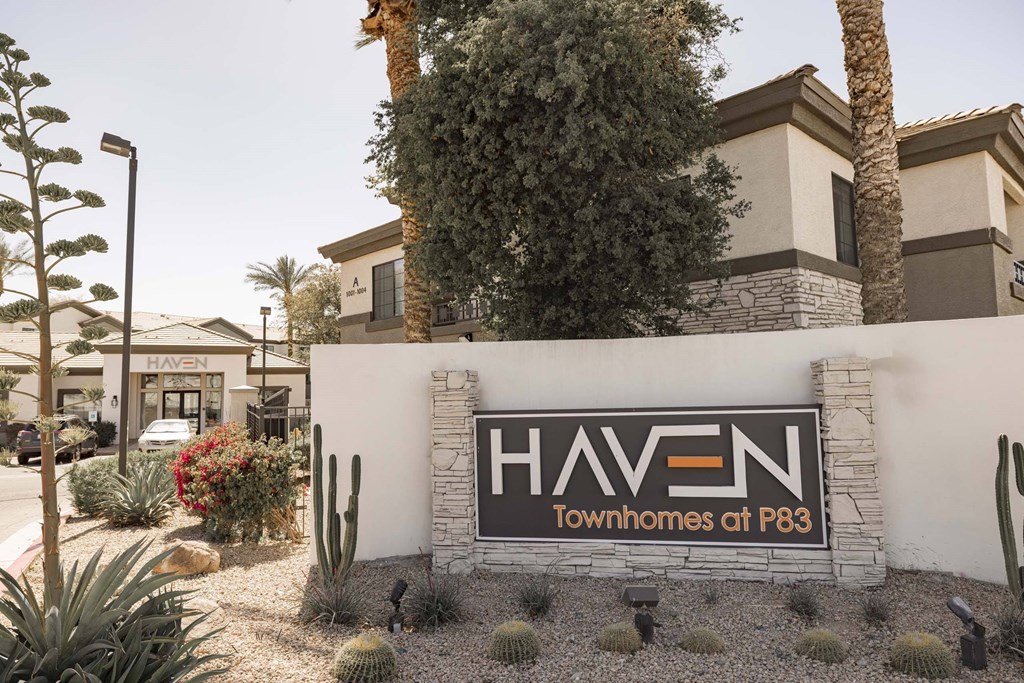 A sign for Haven Townhomes at P83 is displayed in front of a building.