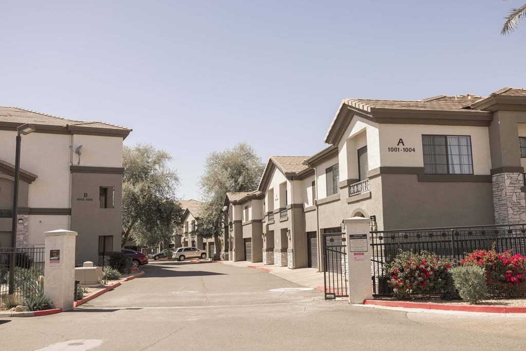 A street view of apartment buildings with a clear blue sky above.